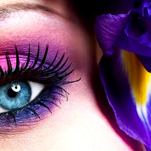 Close-up of a woman’s eye with vibrant makeup, promoting professional beauty and makeup services.